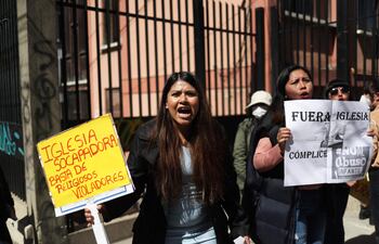 Varias personas protestan en contra de la Iglesia católica pegando carteles en las puertas del seminario San Jerónimo, en La Paz (Bolivia). Colectivos protestaron en Bolivia en contra de la Iglesia católica tras las recientes denuncias de pederastia que involucran a varios sacerdotes, algunos ya fallecidos, para que haya justicia y exigieron que se endurezcan las leyes para proteger a la niñez. (EFE)