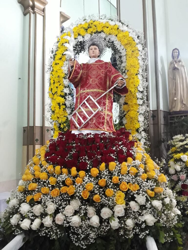 Adornos de flores y follajes adornan la imagen de San Lorenzo.