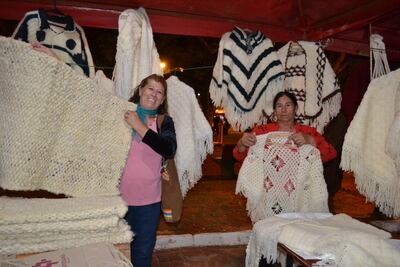 Las artesanas María Andresa Ferreira (i) y Zunilda Portillo de Arazape, exhiben hermosas prendas de lana tejidas a manos.