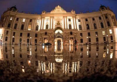 Un solitario ciclista atraviesa la plaza Michaeler en Viena, frente al palacio de Hofburg.