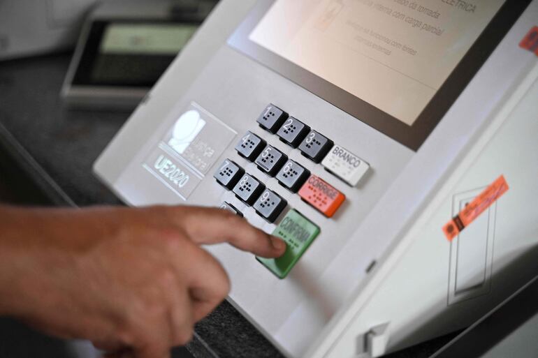 Un funcionario del poder electoral supervisa una máquina de votación en Brasilia. (AFP)