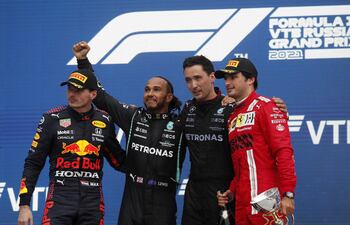 El ingles Lewis Hamilton, con el puño levantado, conquistó el Gran Premio de Rusia y llegó a su victoria número 100 en la Fórmula 1. A lado aparecen en el podio el holandés Max Verstappen (i) y el español Carlos Saiz (d), segundo y tercero, respectivamente en la clasificación final (EFE).
