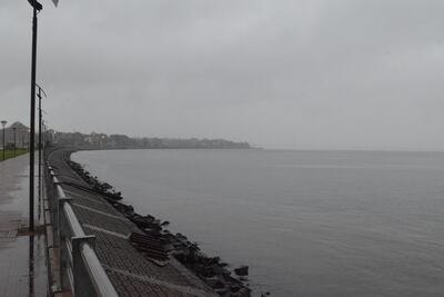 Una suave lluvia comenzó a caer luego del mediodía sobre la ciudad de Encarnación. La vista muestra el río Paraná y la costanera con el puente internacional al fondo que se pierda tras una la cortina de agua.
