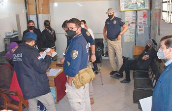 El fiscal Julio Ortiz (der.) y efectivos policiales, en procedimiento.