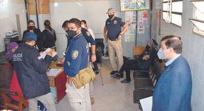 El fiscal Julio Ortiz (der.) y efectivos policiales, en procedimiento.