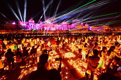 El público observa un show de luces láser en la rivera del río Sarayu, durante las celebraciones en la víspera del festival de Diwali, en Ayodhya, India.