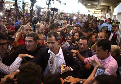 TOPSHOT - Venezuelan opposition leader and self-proclaimed acting president Juan Guaido (C) arrives at Simon Bolivar International Airport in Maiquetia, Vargas state, Venezuela on February 11, 2020. - Guaido returned to Venezuela after a 23-day international tour to revitalize pressure on President Nicolas Maduro, his press team announced. (Photo by Cristian Hernandez / AFP)