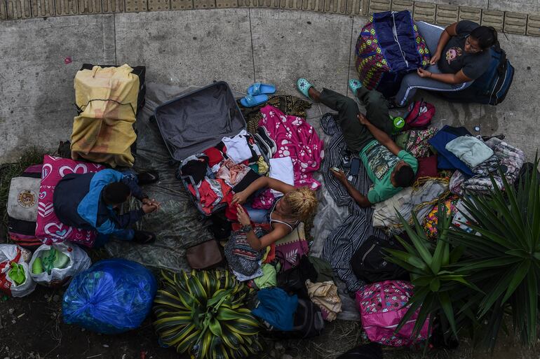 Migrantes venezolanos acampan fuera de una terminal de buses en Medellín, Colombia, esperando regresar a su país.