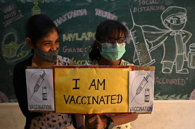 Dos niñas posan para una foto con un cartel que dice "Yo me vacuné", luego de recibir una dosis de Covaxine contra el coronavirus, en su escuela en Chennai, India.