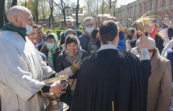 Un sacedote ortodoxo bendice pasteles y huevos de Pascua en un mercadillo en Moscú.