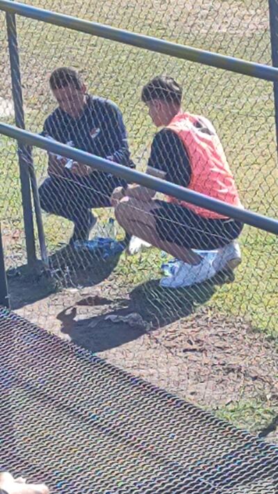 Uno de los integrantes del cuerpo técnico de la reserva de Nacional (i) y uno de los jugadores del plantel (d), mientras cargaban agua de la canilla.