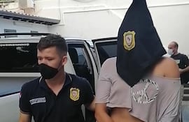 Un agente policial acompaña a la detenida.