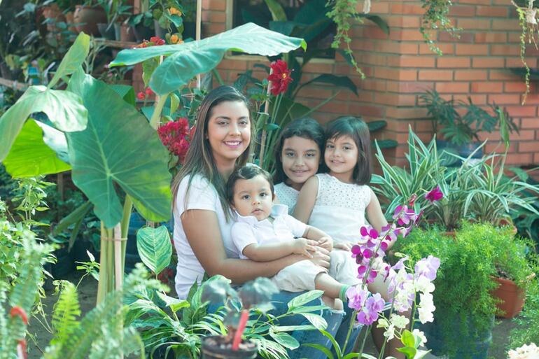 Mara rodeada de plantas y de sus hijos Josefina, Catalina y Tomás.