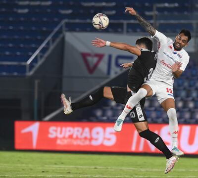 Sin treguas en el duelo aéreo por llegar a la pelota se cruzan el defensor albo Carlos Rolón (19) y Nelson da Silva.