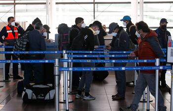 Un grupo de viajeros espera para facturar sus maletas en el aeropuerto Internacional Arturo Merino Benítez de Santiago (Chile).