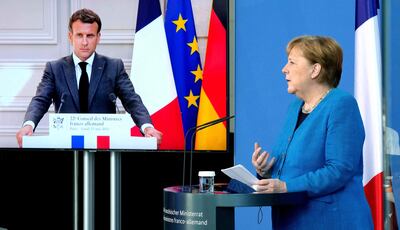 El presidente francés Emmanuel Macron (en pantalla) y la canciller alemana Angela Merkel durante una conferencia de prensa este lunes.