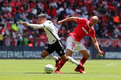 Lucas Rodríguez (i), del Tijuana, disputa el balón con Carlos González (d), del Toluca, hoy, durante un partido por la jornada 7 del Torneo Apertura 2022 de la Liga MX entre Toluca y Tijuana, en el estadio Nemesio Diez, en Toluca, Estado de México (México).