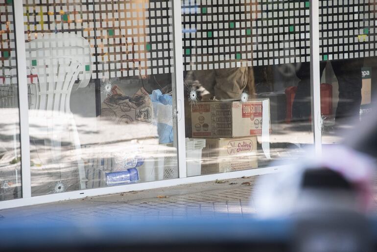 Vista de impactos de bala en el supermercado de la familia de Antonela Roccuzzo, que fue atacado a tiros por dos personas cerca de las 3 de la madrugada, en Rosario (Argentina). Además de los disparos, en el lugar se encontró un mensaje dedicado al capitán de la selección argentina, recientemente galardonado con el premio The Best: "Messi te estamos esperando, (el intendente de Rosario, Pablo) Javkin también es narco, no te va a cuidar". Según se describió, fueron efectuados 14 disparos contra la fachada del local de la familia Rocuzzo.