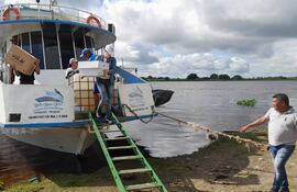 Una funcionaria de la Justicia Electoral procede a bajar los útiles electorales en el puerto de Fuerte Olimpo.