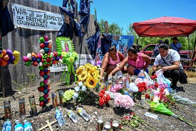 La gente coloca flores y velas en un monumento improvisado donde se descubrió un camión con remolque con migrantes adentro, en las afueras de San Antonio, Texas, el 29 de junio de 2022.