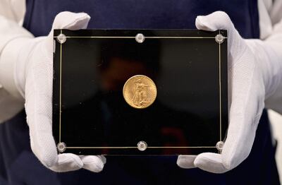 Un empleado de Sotheby's sostiene la moneda de 1933, vendida a un precio récord de US $19.5 millones.