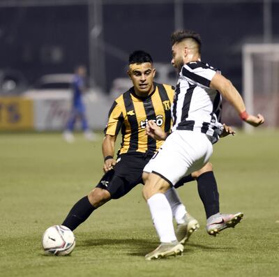 Héctor Villalba, autor de un golazo, busca eludir a Benítez, que sufrió un corte en la cabeza.