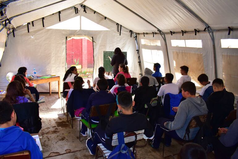 Los alumnos desarrollan sus actividades escolares con penurias bajo las precarias carpas.