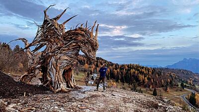Situado sobre una colina en los bosques italianos de Lavarone, en la provincia norteña de Trento, se alza un enorme dragón alado que, construido por el artista Marco Martalar con la leña de los árboles derribados por el temporal Vaia, custodia los mismos bosques que fueron arrasados en 2018.