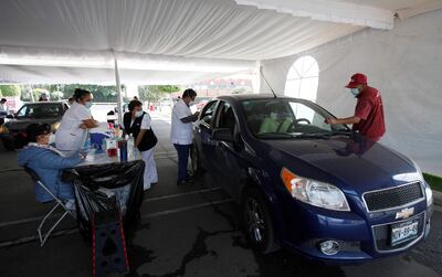 Un hombre recibe desde su vehículo la vacuna contra el COVID-19 en un módulo de vacunación vehicular hoy, en el municipio de Tlalnepantla (México).