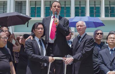El abogado Daniel Wong Kwok-tung (i) junto a sus colegas, antes de ser detenido por la policía.