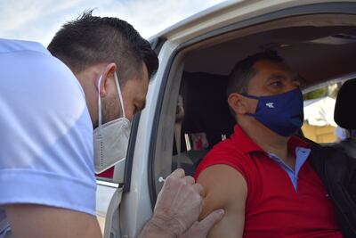 Un personal de blanco del Hospital Regional aplicaba la primera dosis anticovid a una paciente en el autovac de Villarrica.