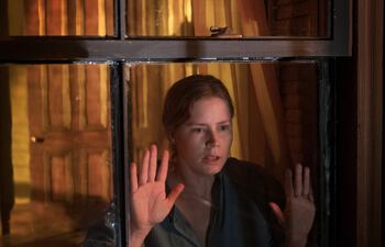 La actriz Amy Adams en una escena de "La mujer en la ventana", que se estrenará este viernes en Netflix.