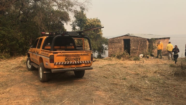 Los bomberos y familiares aguardando la llegada de los intervinientes para proceder al levantamiento del cuerpo sin vida de Gilberto Centurión