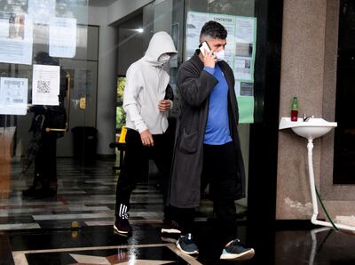 Juan Carlos Ferreira se retira del juzgado, hablando a través de un teléfono celular. Le sigue su hijo Sebastián. Fue ayer a la tarde.