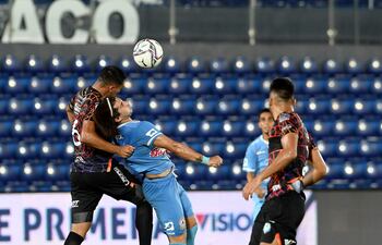 Miguel Paniagua, de Guaireña, lucha por el balón con el delantero Diego Martínez, reflejando lo peleado del juego en el Defensores del Chaco.