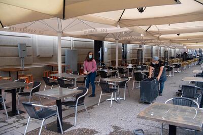 Trabajadores preparan las mesas de un restaurante de la ciudad de Santiago, en medio de la relajación de restricciones en Chile.