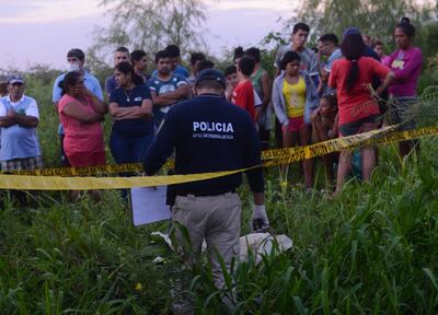 Un agente policial inspecciona el cuerpo hallado a orillas del río Paraguay, cerca de la Prefectura Naval de Puerto Botánico.