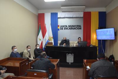 El Ing. Víctor Mongelós, técnico de la entidad binacional Yacyreta (EBY) expone ante la Junta Municipal de Encarnación aspectos del proyecto de reposición funcional del FFCC, afectada por la construcción de la represa de Yacyreta. A su lado el presidente de la Junta, Andrés Morel (ANR). En el frente el intendente Sebastián Remezowski, entre otros