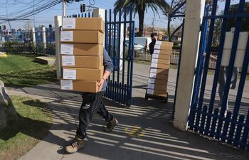 Simón Boric, el hermano del presidente chileno, Gabriel Boric, que fue agredido el jueves por un grupo de desconocidos. Trabajadores cargan hoy cajas con papeletas de votación, durante la preparación de las urnas en un centro de votación en el Colegio Nueva Era Siglo XXI, en la comuna de Puente Alto, Santiago (Chile).