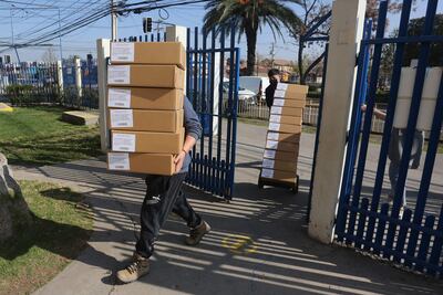 Simón Boric, el hermano del presidente chileno, Gabriel Boric, que fue agredido el jueves por un grupo de desconocidos. Trabajadores cargan hoy cajas con papeletas de votación, durante la preparación de las urnas en un centro de votación en el Colegio Nueva Era Siglo XXI, en la comuna de Puente Alto, Santiago (Chile).