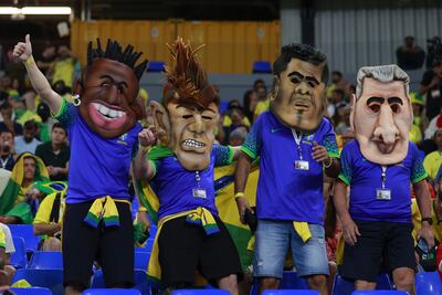 Aficionados de Brasil posan con máscaras de los jugadores de Brasil Vinicius Jr. (i), Neymar (2-i) y Dani Alves (2-d) y el entrenador Tite, a un partido de la fase de grupos del Mundial de Fútbol Qatar 2022 entre Brasil y Suiza en el estadio 974 en Doha (Catar). EFE/ Antonio Lacerda