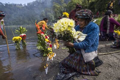 Indígenas participan en una ceremonia en la que, con ofrendas florales, agradecen a la naturaleza por la lluvia, hoy, en la laguna de Chicabal (Guatemala). Esta laguna, considerada sagrada por el pueblo maya mam, está asentada en el cráter del volcán Chicabal a 2.000 metros de altura sobre el nivel del mar y se ubica en el departamento (provincia) de Quetzaltenango, 220 kilómetros al oeste de la Ciudad de Guatemala. Esta costumbre, con cientos de años de historia, es considerada por los guías espirituales mayas como una ceremonia que conecta a los creyentes con la naturaleza y sus ancestros.