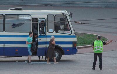 Un oficial de policía dirige a tres rehenes liberados de un autobús secuestrado en el centro de la ciudad de Lutsk, Ucrania occidental, ayer 21 de julio de 2020. Según los medios locales, un armado el hombre había tomado el autobús de cercanías con 39 pasajeros y conductor rehén. Según los funcionarios, Plokhoy, el secuestrador, es un delincuente convicto y tiene antecedentes de trastornos mentales.