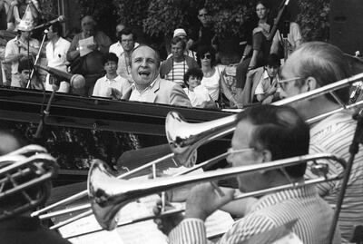 Claude Bolling sentado al piano y sonriendo en una fotografía de archivo.