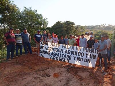 Manifestantes sobre el arroyo Mbatay, pidiendo un puente seguro.