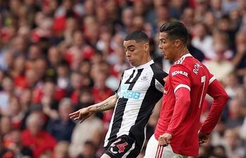 Miguel Almirón disputa el balón Cristiano Ronaldo, quien marcó ayer dos goles en su regreso al Manchester United.