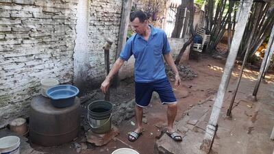 Oscar Villalba, usuario de la Junta de Saneamiento de Ñemby, abre la canilla y ni una gota