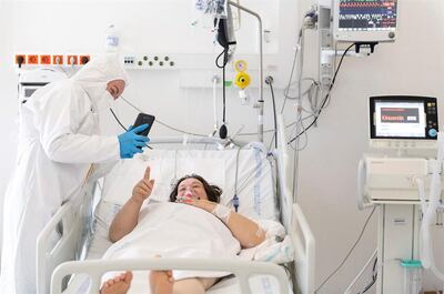 Una enfermera le muestra fotos de sus hijos a una paciente internada con coronavirus.