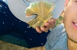 El funcionario Carlos Heinrich sosteniendo un fajo de billetes, el mismo alegó que fue en el contexto de una carrera de caballos el fin de semana.