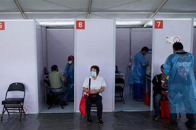 Personas mayores esperan para recibir la primera dosis de la vacuna china Sinovac contra la Covid-19 hoy, en un centro habilitado para la vacunación en masa, en Santiago (Chile).